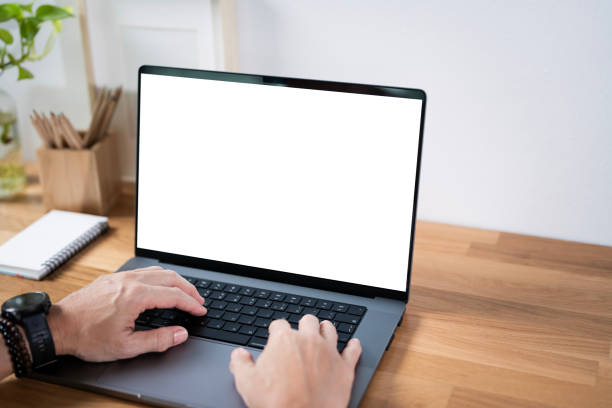 istock Close-up image of a man working on laptop computer at a table, typing on the laptop keyboard. the laptop with a white screen mockup 2179864266