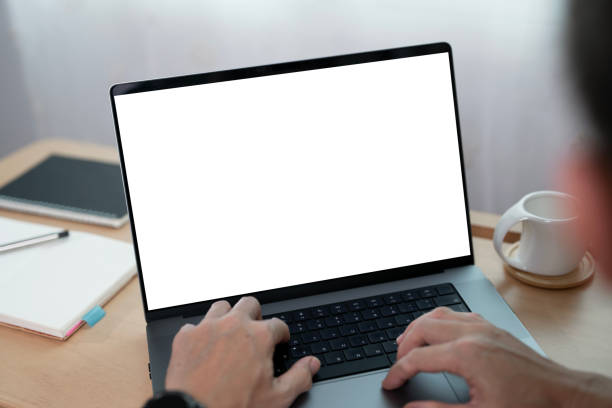 istock Close-up image of a man working on laptop computer at a table, typing on the laptop keyboard. the laptop with a white screen mockup 2179864307