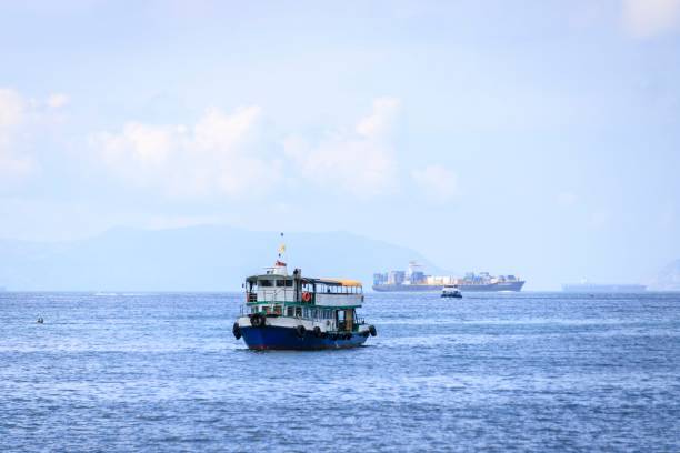 istock Small Boat and Cargo Ship on a Calm Sea 2179867513