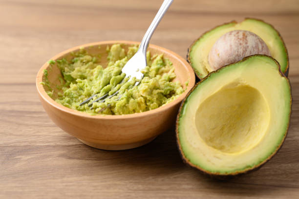 istock Smashing avocado in wooden bowl by fork 2179877612