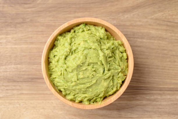 istock Mashed avocado in bowl on wooden background, Healthy eating 2179877617