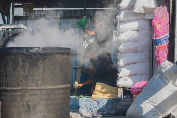 Balikpapan, Indonesia - September 12th, 2024. The coin crackers they are making are still long and sausage-shaped before he cuts them.
