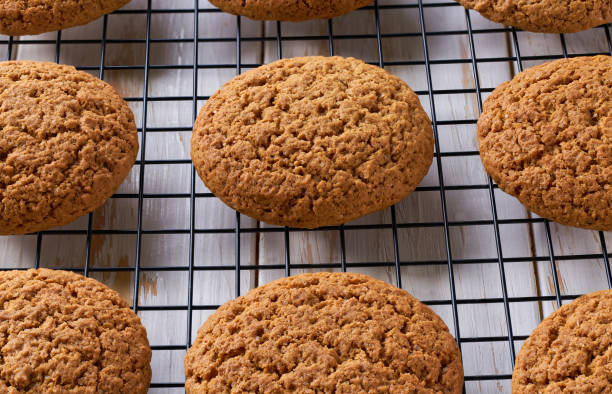 istock Oatmeal cookies in a black wire rack on a white table, close up. 2179887907