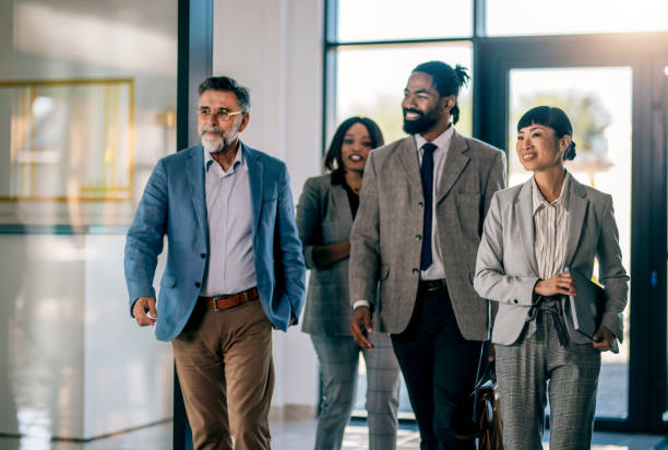 istock Coworkers talking while walking through corridor at office 2179891811