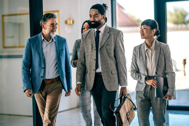 istock Coworkers talking while walking through corridor at office 2179891926