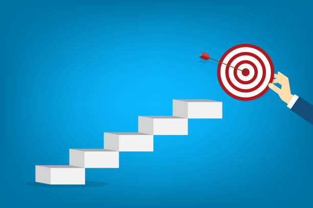istock Hand holding a target, showing a goal. Red arrow hits the center. Business challenge failure and success concept. 2179894972