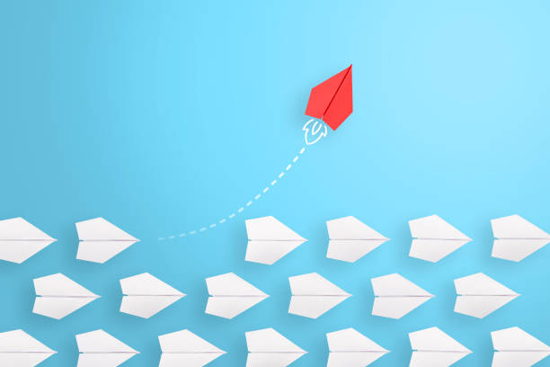 Group of paper plane in one direction and with one individual pointing in the different way, can be used leadership/individuality concepts. New idea, change, trend, courage, creative solution, innovation and unique way concept.