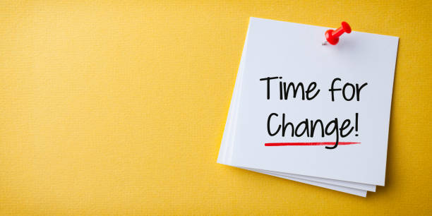 istock White Sticky Note With Time for Change And Red Push Pin On Cork Board. 2179903091
