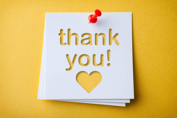 White Sticky Note With Thank You And Red Push Pin On Yellow Cardboard.