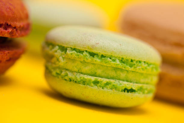Close up green tea flavour macaroon over yellow background.
