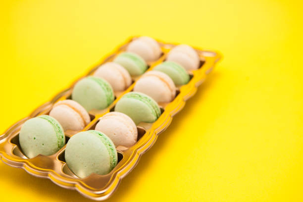 Taditional fresh macaroons over yellow background. Tasty snack