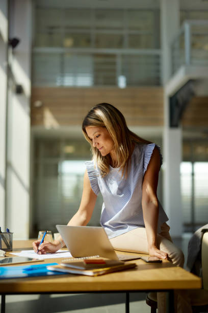 istock Smiling female entrepreneur taking notes in the office. 2179908115