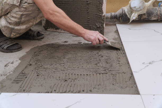 istock Construction worker applies cement for laying floor ceramic tiles with spatula 2179911607