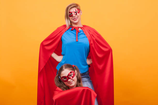 istock Mother and daughter playing together dressed like superheros 2179911795
