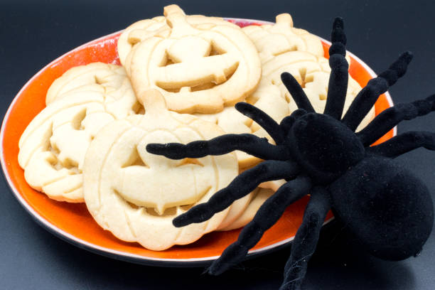 istock Plate with Halloween pumpkin-shaped cookies and a spider on a black background. 2179915264