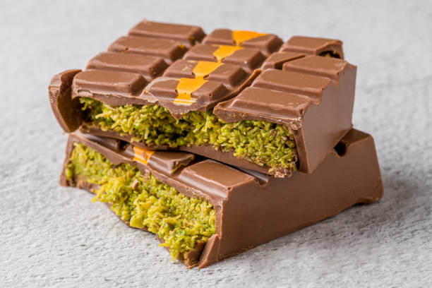 istock Dubai Chocolate bar with green kadayif and peanut butter on white stone table 2179916055