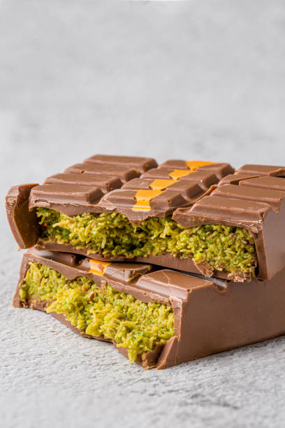 istock Dubai Chocolate bar with green kadayif and peanut butter on white stone table 2179916057