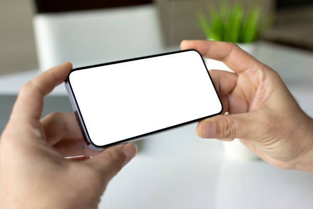 istock male hands holding phone horizontally with isolated screen cafe table 2179916824