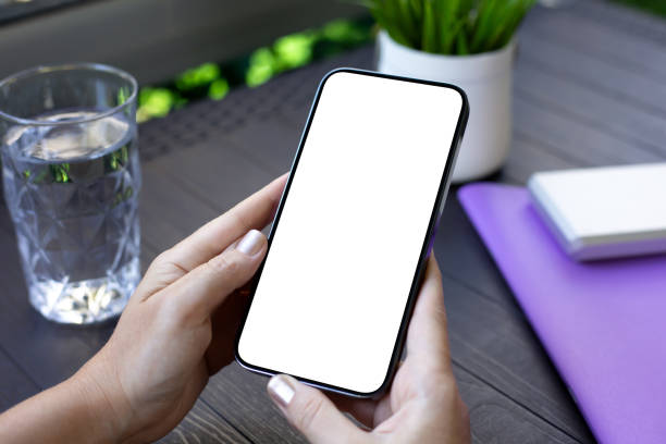 istock female hands holding phone with isolated screen table in cafe 2179916941