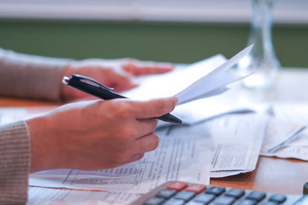istock Close-up Hands calculating taxes on a desk 2179920259