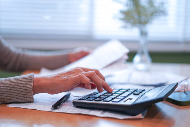 istock Hands managing finances and preparing tax calculations 2179920298