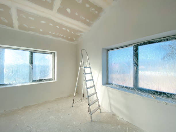 istock New empty house interior with white freshly painted walls, step ladder, plastic on the windows, and no people. Interior renovation 2179922510