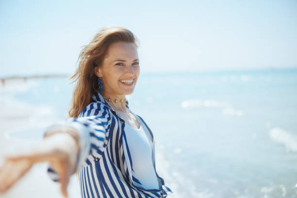 istock happy elegant woman on ocean shore having fun time 2179927495