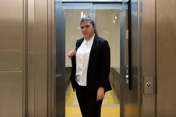 istock usinesswoman Looking at Camera Inside a Corporate Building Elevator 2179927626