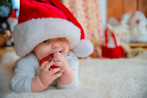 istock Baby in Santa Hat Holding Ornament 2179928052