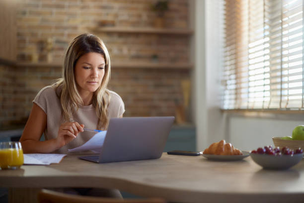 istock Woman working on reports and laptop at home. 2179928753