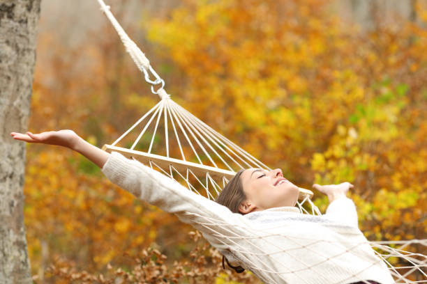 istock Happy woman celebrating autumn vacation on hammock 2179930166