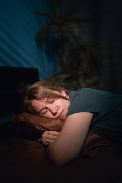 istock Lazy Woman with peaceful face sleeping in bed at night 2179931133