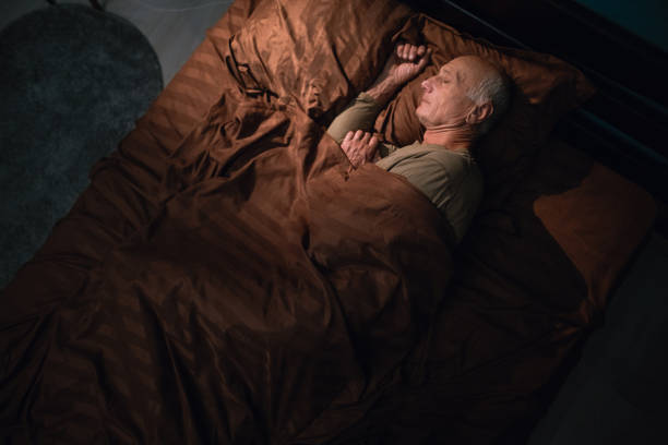 istock Elderly man peacefully sleeping in cozy bed resting 2179931159