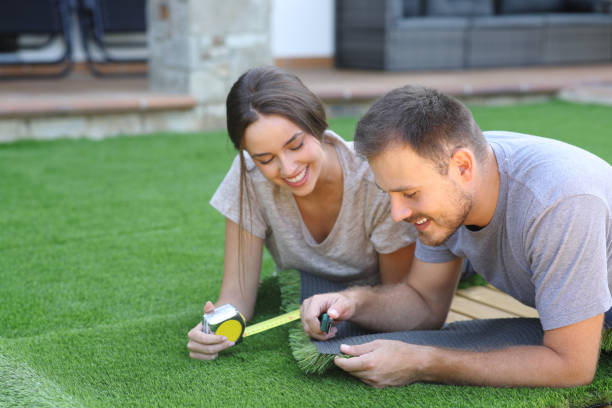 istock Happy couple installing together artificial grass in the garden 2179932064
