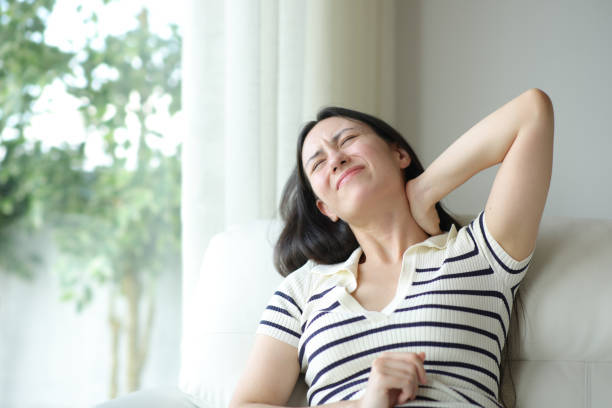 istock Stressed asian woman suffering neck ache on uncomfortable couch 2179932446