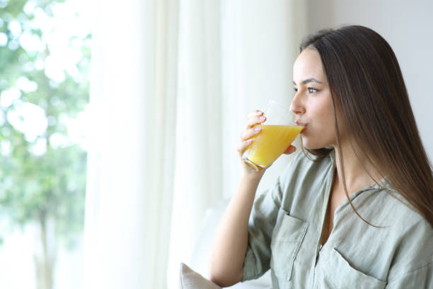 istock Woman drinking orange juice in a house 2179932502