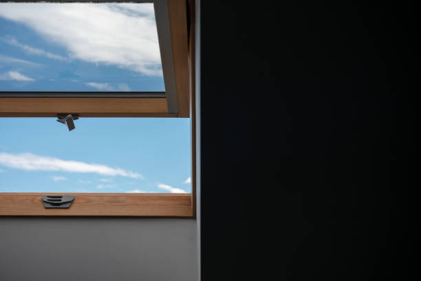 istock Window with a blue sky outside and a black wall next to it 2179934096