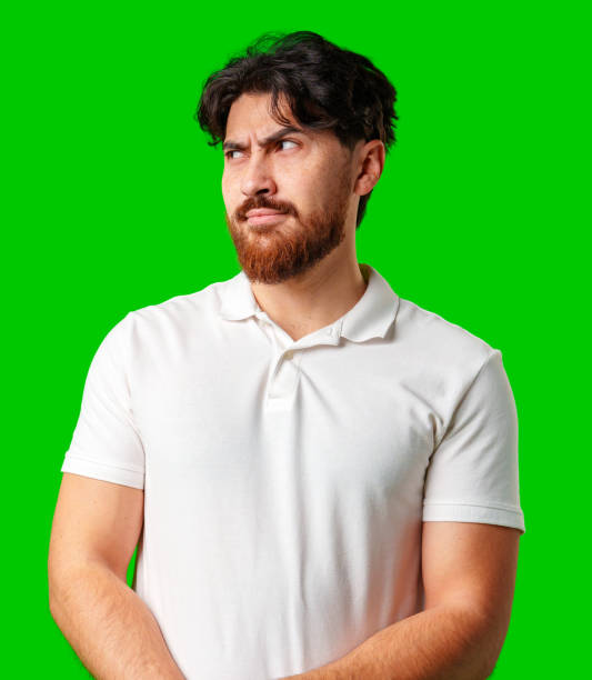 istock A young man with a beard showing a serious expression against a vibrant green background 2179934334