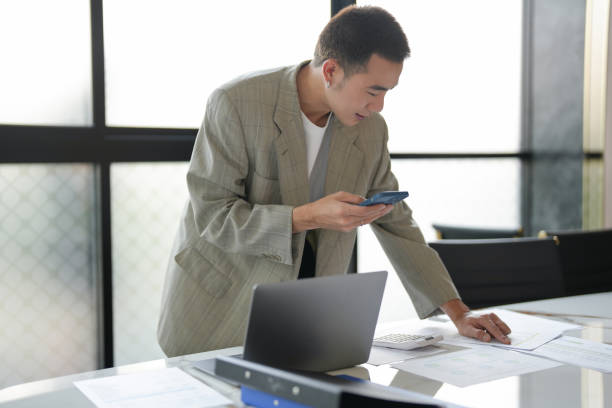 istock asian business man holding Smartphone working mobile devices. cell telephone technology e-commerce smartphone for business 2179937600