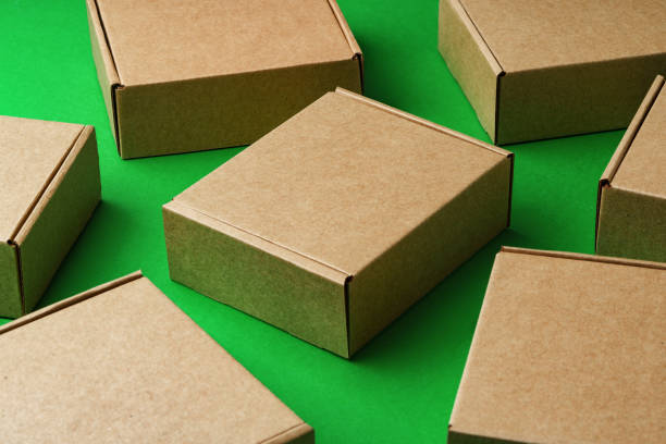 istock Brown cardboard boxes arranged on a vibrant green surface 2179939034