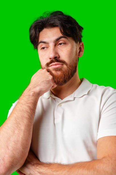 istock A man with a serious expression stands against a vibrant green background 2179940175