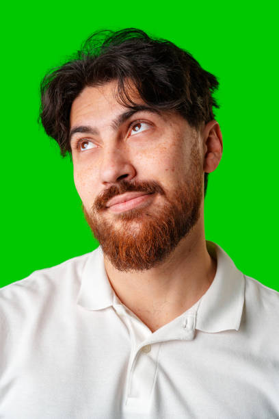 istock A man with a beard smiles confidently against a bright green background 2179940960