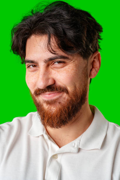 istock A man with a beard smiles confidently against a bright green background 2179941990