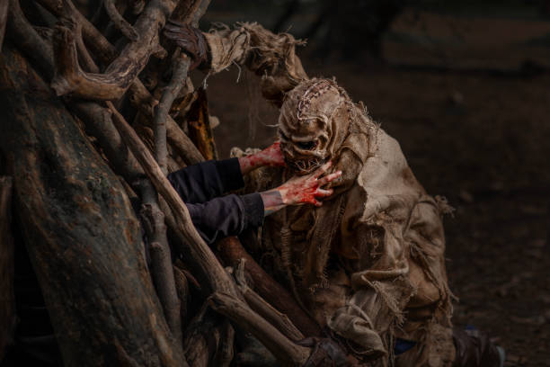 istock Hands trapped in a cage reaching for.a Halloween Scarecrow in a forest 2179942616