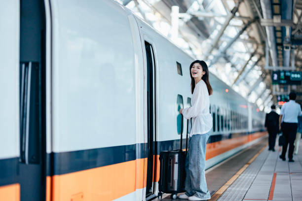 istock A female backpacker drags her suitcase into the train carriage, her face lit up with excitement as she eagerly looks forward to her trip. 2179943648