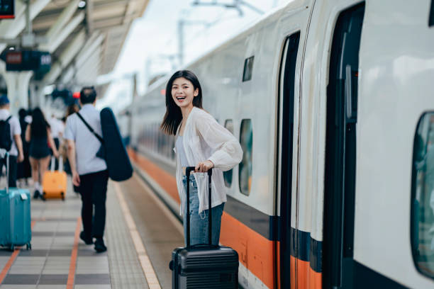 istock A female backpacker drags her suitcase into the train carriage, her face lit up with excitement as she eagerly looks forward to her trip. 2179943726