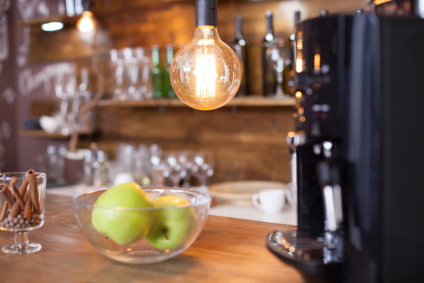 Interior elements of cozy coffee shop with blurred coffee machine in the background. Wooden bar counter.
