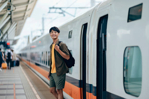 istock A male backpacker drags her suitcase into the train carriage, smiling with excitement as she looks forward to her trip. 2179944855