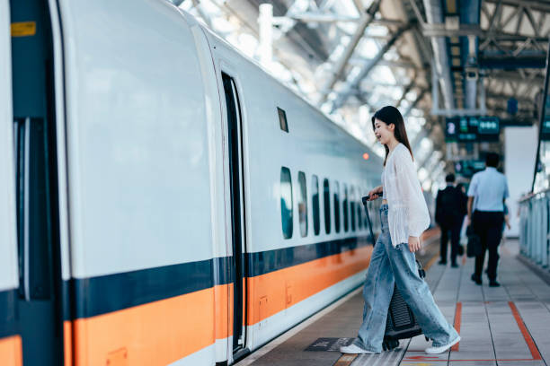 istock A female backpacker drags her suitcase into the train carriage, her face lit up with excitement as she eagerly looks forward to her trip. 2179945635
