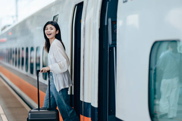 istock A female backpacker drags her suitcase into the train carriage, her face lit up with excitement as she eagerly looks forward to her trip. 2179945809